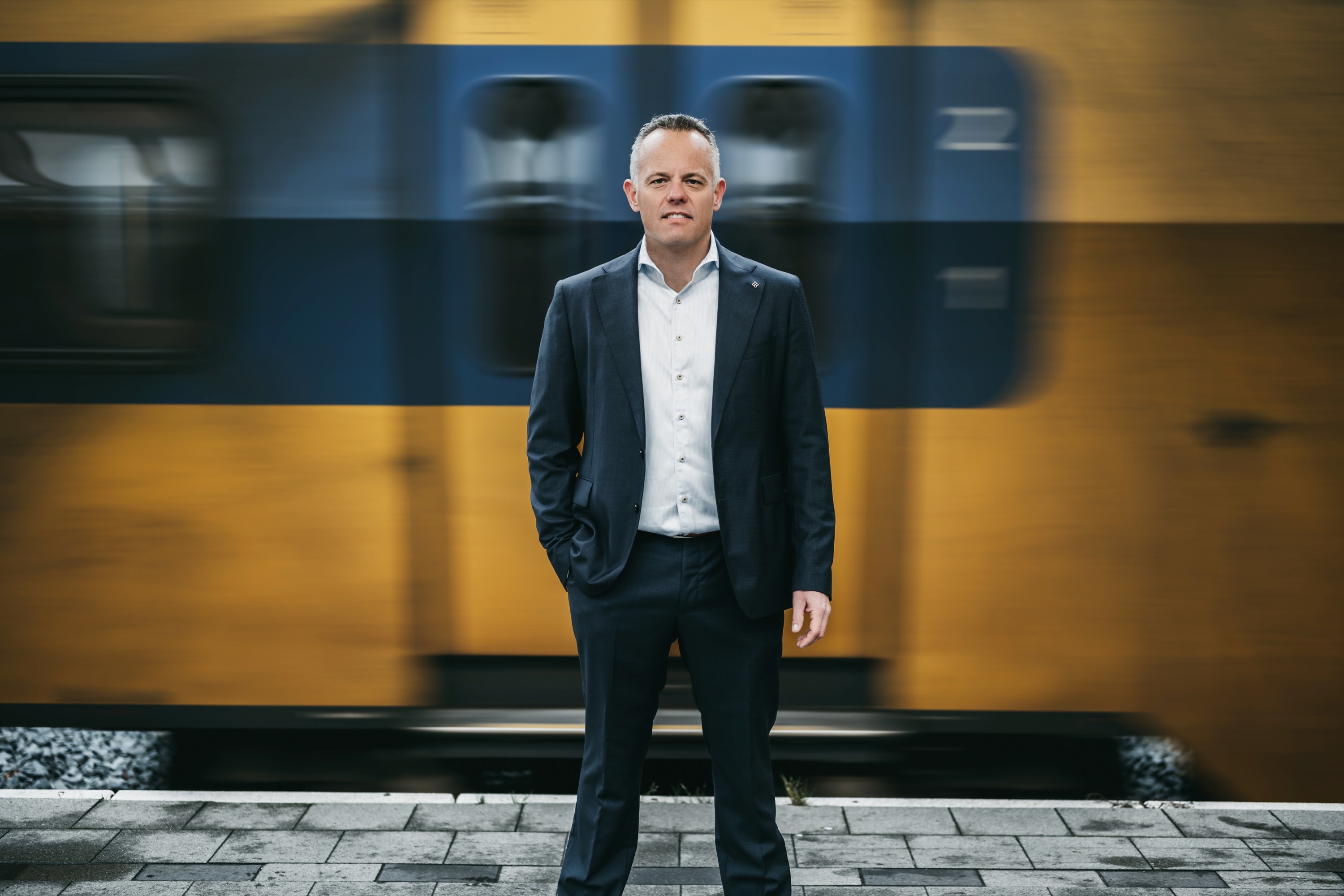 Portret van Nico Hanhart op een treinperron